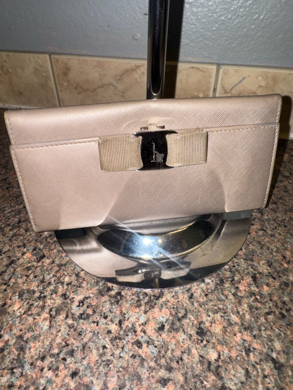 Salvatore Ferragamo taupe bow wallet.